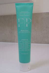 Front of a 100g Flossy & Pure Mild Mint nano-hydroxyapatite toothpaste tube on a bathroom bench