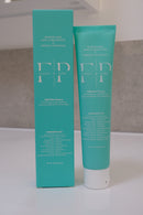 Flossy & Pure Mild Mint nano-hydroxyapatite toothpaste, 100g tube standing beside its teal carton on a bathroom bench